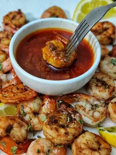 a plate full of shrimp and dipping sauce