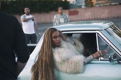 a woman leaning out the window of a car