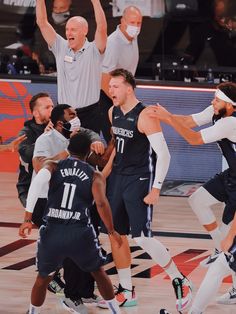 a group of men playing basketball on top of a court