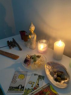 a table topped with cards and candles next to a lit candle on top of it