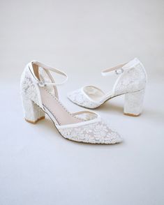 a pair of white bridal shoes with lace