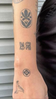 a woman's arm with tattoos on it, including an owl and other symbols