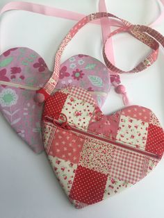 two heart shaped purses sitting next to each other