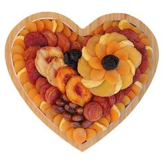 a heart shaped platter filled with dried fruit, nuts and raisins on a white background