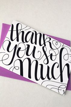 a thank you're much card sitting on top of a purple and white envelope