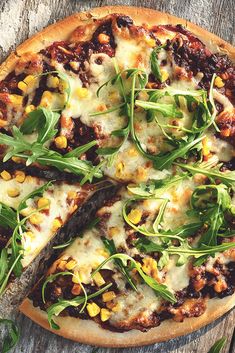 a pizza topped with lots of toppings on top of a wooden table