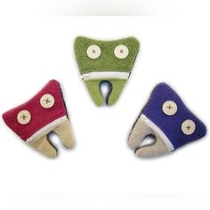 three felt toothbrush holders with buttons on them