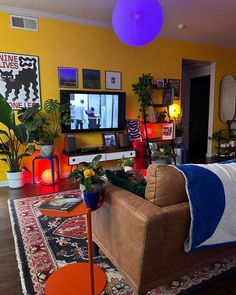 a living room filled with furniture and a large flat screen tv mounted to the wall