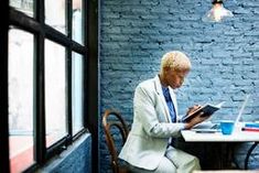 a person sitting at a table with a laptop