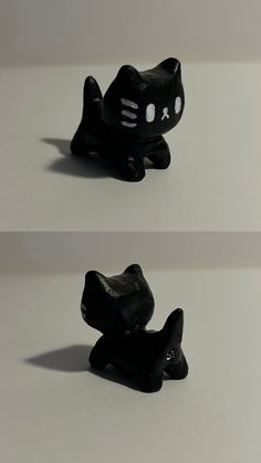 two small black cat figurines sitting next to each other