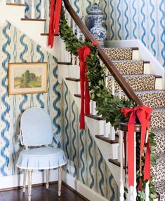 the stairs are decorated with red bows and greenery for holiday decor in this home