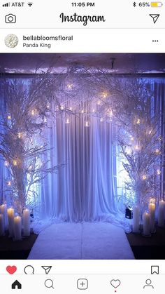 an image of a stage set up with candles and trees in the background for a wedding