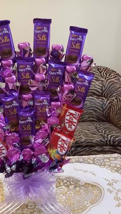 a vase filled with chocolates and candy bar wrappers on top of a table