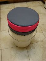 a black and red stool sitting on top of a tiled floor