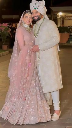 the newly married couple poses for a photo in their wedding outfits at night time,