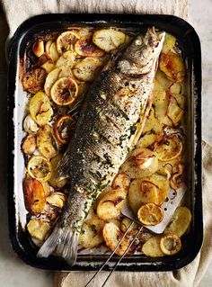 a fish and potatoes on a baking sheet