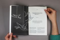 a person holding an open book with drawings on the pages and in front of them