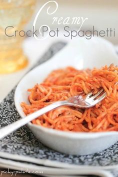 a white bowl filled with spaghetti on top of a table