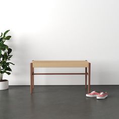 a wooden bench sitting next to a potted plant