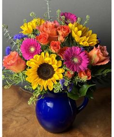 a blue vase filled with lots of colorful flowers