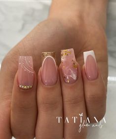 a woman's hand with some pink and gold nail polishes on her nails