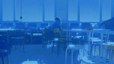 two people sitting at tables in a room with large windows and blue lighting on the walls