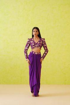 Purple Dhoti Set | Deepika Chadha Deepika Chadhai's luxury look Blouse and dhoti set, crafted from rich crepe fabric. This exquisite ensemble is designed to make a statement with a vibrant purple tone perfect for your extravagant look for your festivities. The dhoti features a flowy look paired with an embellished blouse completing the fusion look. Included in Purchase: Blouse & Dhoti Set Product Specification Color: Purple Fabric: Georgette, Sheesha Crepe Neckline: V-neck Occasion: Bridal, Engagement, Formal Event Designer: Deepika Chadha Work: Hand Embroidery-Sequins, Zari, Crystals Care Instructions: Dry Cleaning only, No Flat Ironing on Hand Embroidery *Jewelry sold separatelyCustomization options:Can be customized in any color or blouse style Note: A stylist will contact you to confir Elegant Purple Sets For Diwali, Unstitched Purple Pre-draped Saree With Dori Work, Purple Art Silk Pre-draped Saree For Navratri, Elegant Purple Reception Sets, Purple Georgette Pre-draped Saree For Eid, Silk Purple Sets For Diwali, Purple Silk Sets For Diwali, Bollywood Style Purple Palazzo Set For Party, Fitted Purple Palazzo Set For Diwali