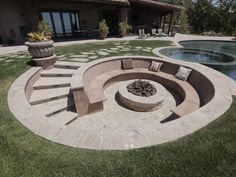 an outdoor fire pit in the middle of a lawn