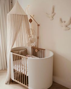 a baby crib in the corner of a room with two birds on the wall