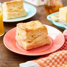 two plates with slices of bread on them and orange juice in the glass behind them