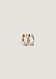 The pavé setting originates from the French word “to pave”—each earring is paved with nine diamonds, adding a little extra to your every day stack. If you're looking for something thicker, shop our Pavé Hoop Huggie Earrings II. Complete the look with the Petite Hoop Huggie Earrings. Featuring nine round diamonds on each earring.Secure snap hinge closure. 14k solid gold—alwaysWeight: Approx 0.7g per earringWidth: 1.5mmCarat weight: 0.09cw per earringClarity: SI 1-2Color: G Timeless Gold Diamond Earrings With Pave Setting, Yellow Gold Diamond Earrings With Cubic Zirconia, Luxury Diamond Huggie Earrings With Pave Setting, Diamond Pave Setting Huggie Earrings, Timeless 14k Gold Huggie Earrings With Diamond Accents, Fine Jewelry Diamond Earrings With Single Cut Diamonds, 14k Gold Earrings With Single Cut Diamonds, Diamond White 14k Gold Hoop Earrings With Diamond Accents, Timeless Diamond Earrings With Pave Setting For Anniversary