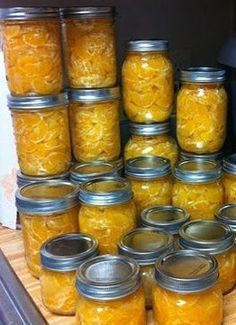 many jars filled with food sitting on top of a wooden table