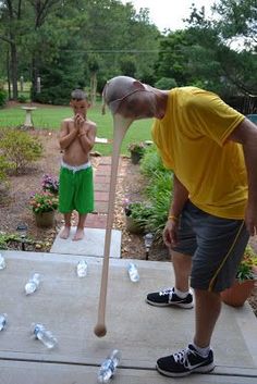 a man holding a baseball bat on top of a cement slab next to another man