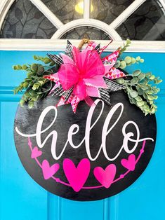 the door is decorated with pink and black hearts, greenery, and hello written on it