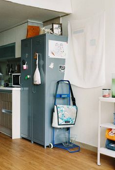 a kitchen with a blue refrigerator next to a wooden floor