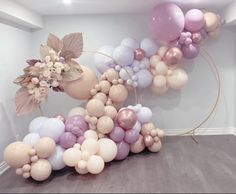 a bunch of balloons that are on the ground in front of a wall with flowers