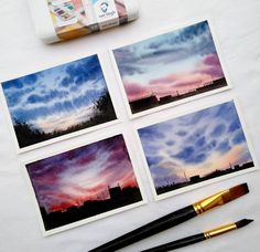 four pictures are being displayed on a table with paintbrushes and watercolors