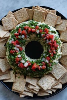 a black plate topped with tortilla chips covered in salsa and garnish