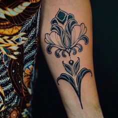 a black and white flower tattoo on the arm