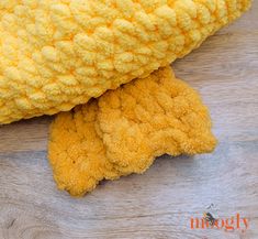 a yellow stuffed animal laying on top of a wooden floor