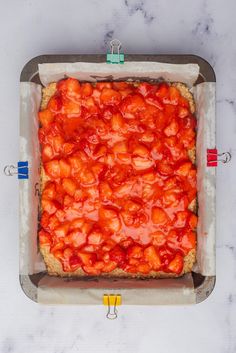 a square pizza sitting on top of a pan covered in tomato sauce and ketchup