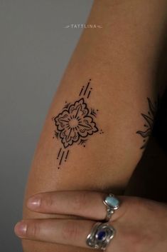 a woman's arm with a small tattoo on the left side of her arm