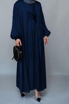 Introducing the Vidonia 2 Piece Luxury Abaya from Annah Hariri, the epitome of sophistication and style. This stunning abaya set is crafted from high-quality satin fabric, ensuring both comfort and durability. The Navy color exudes luxury and will leave a lasting impression wherever you go.The abaya features a maxi slip dress with maxi sleeves that provide full coverage and comfort. The wrap bodice adds a touch of elegance and femininity, while the elasticated cuffs offer a secure and snug fit. Elegant Solid Color Dresses For Eid, Evening Solid Color Maxi Length Abaya, Evening Solid Maxi Length Abaya, Eid Evening Solid Color Abaya, Evening Maxi Length Solid Abaya, Eid Wedding Solid Color Abaya, Elegant Silk Maxi Abaya, Silk Maxi Abaya For Eid, Elegant Solid Color Abaya For Eid