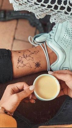 a person with a tattoo on their arm holding a coffee cup