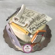 a cake that is shaped to look like a house with construction drawings on it and a calculator