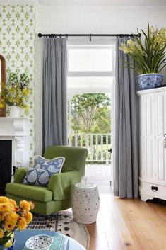 a living room filled with furniture and flowers on top of a wooden floor next to a fire place