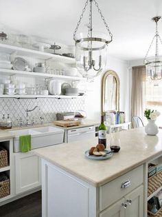 a kitchen filled with lots of white appliances and counter top space next to a window