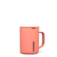 a pink coffee mug sitting on top of a white table