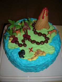 a birthday cake decorated with an island and palm trees on the top is blue icing