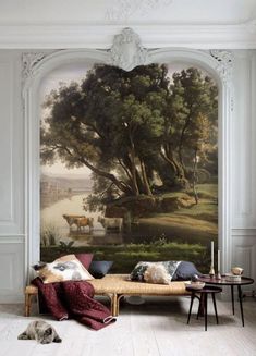 a living room filled with furniture and a painting on the wall